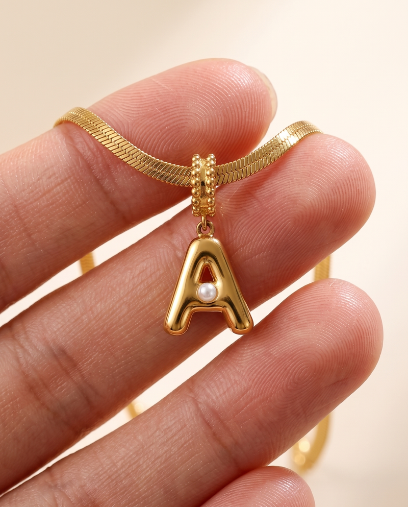 Collana Alma con lettera A in acciaio 316L PVD oro, perlina nella curva