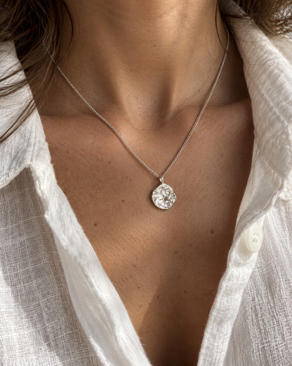Collana Duna indossata con camicia bianca, pendente martellato argento sotto la clavicola