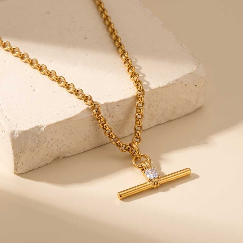 Collana Isla T-bar appoggiata su un blocco di gesso crema, dettaglio dello zircone