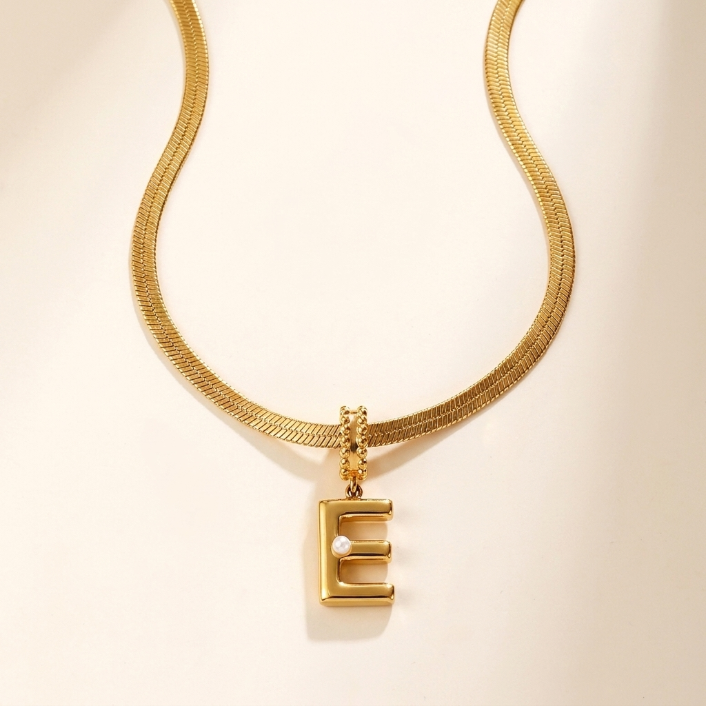 Collana Alma con iniziale bombata e perla su catena herringbone, acciaio 316L PVD oro