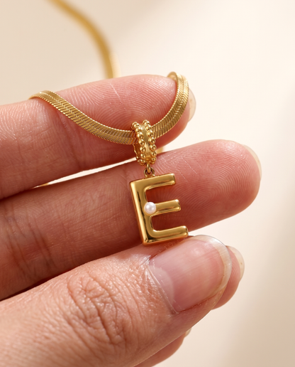 Collana Alma con lettera E in acciaio 316L PVD oro, perlina nella curva