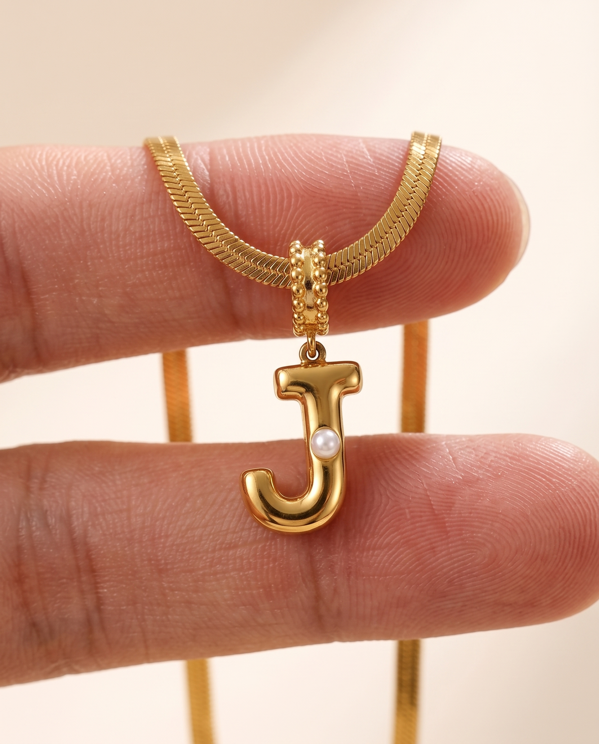 Collana Alma con lettera J in acciaio 316L PVD oro, perlina nella curva