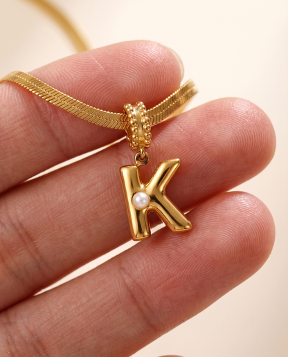 Collana Alma con lettera K in acciaio 316L PVD oro, perlina nella curva