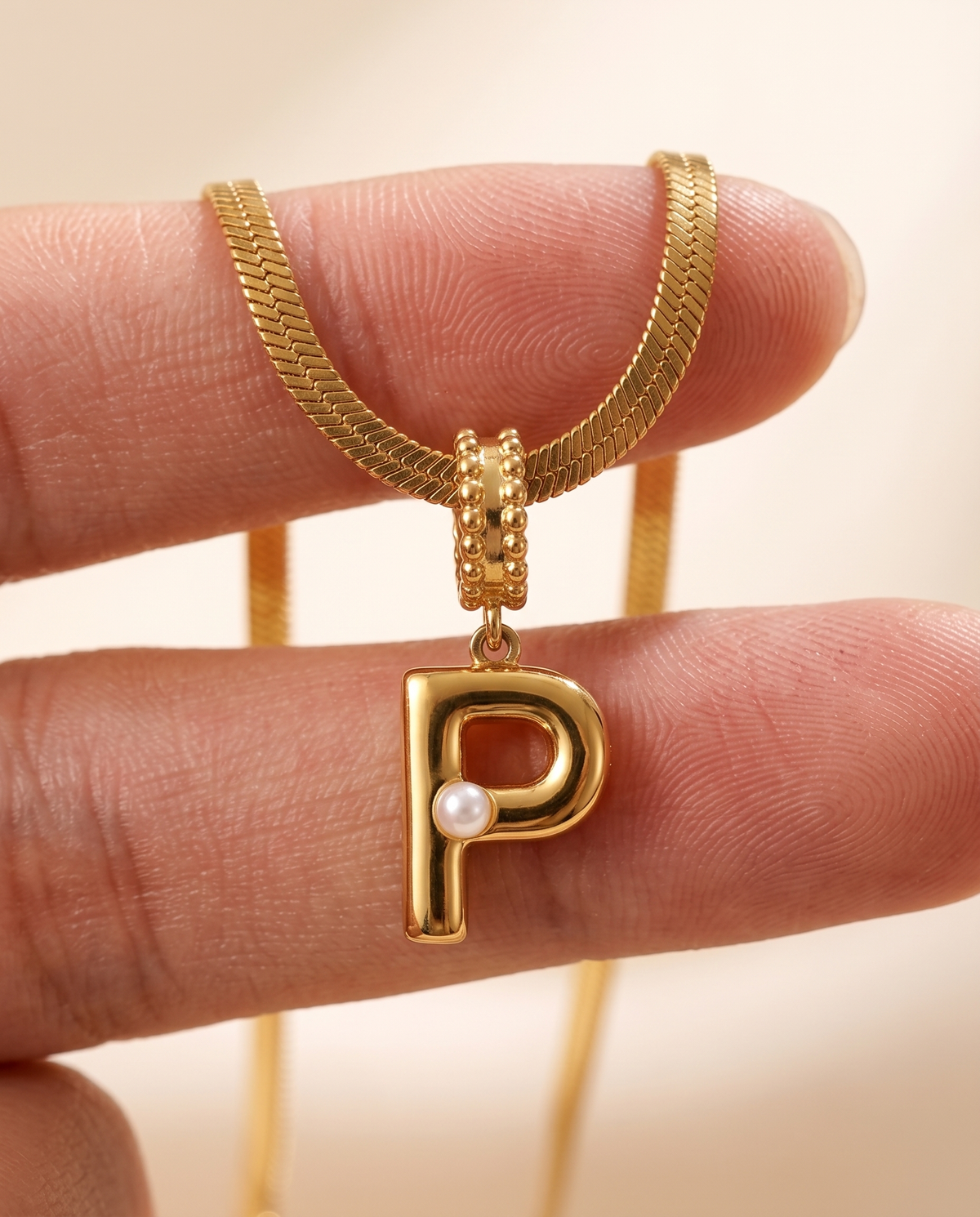 Collana Alma con lettera P in acciaio 316L PVD oro, perlina nella curva