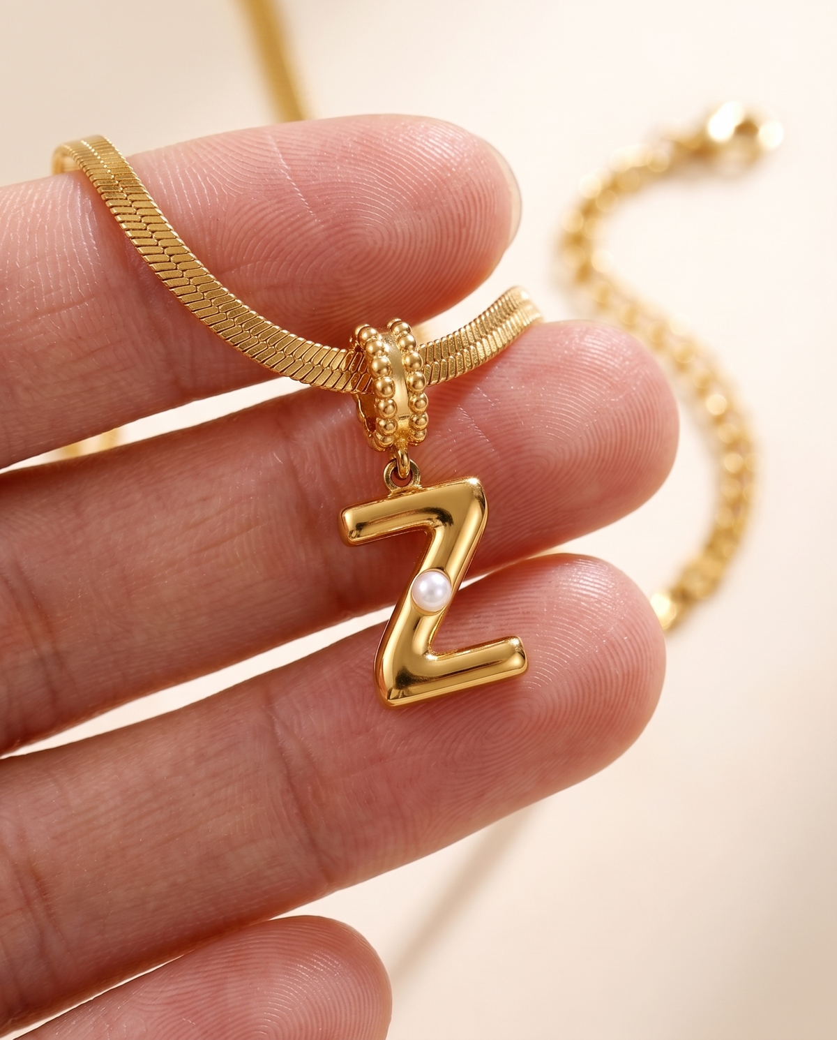 Collana Alma con lettera Z in acciaio 316L PVD oro, perlina nella curva