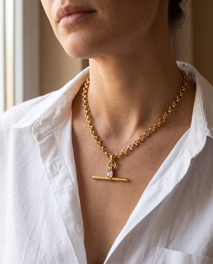 Collana Isla indossata: T-bar con zircone quadrato appoggiata alla base del collo, su camicia bianca