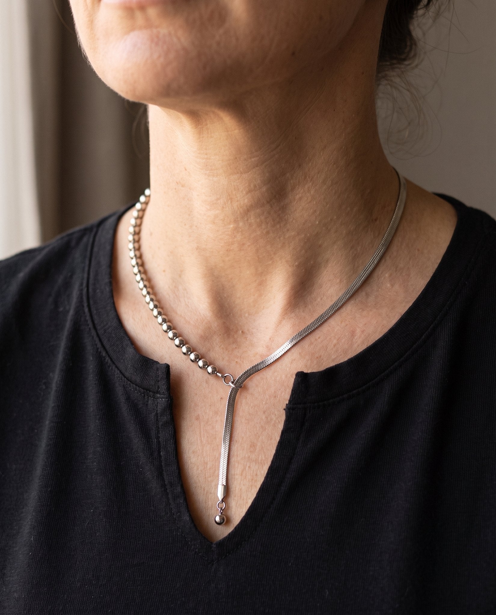 Collana Neo indossata su t-shirt nera, il drop scende al centro del petto