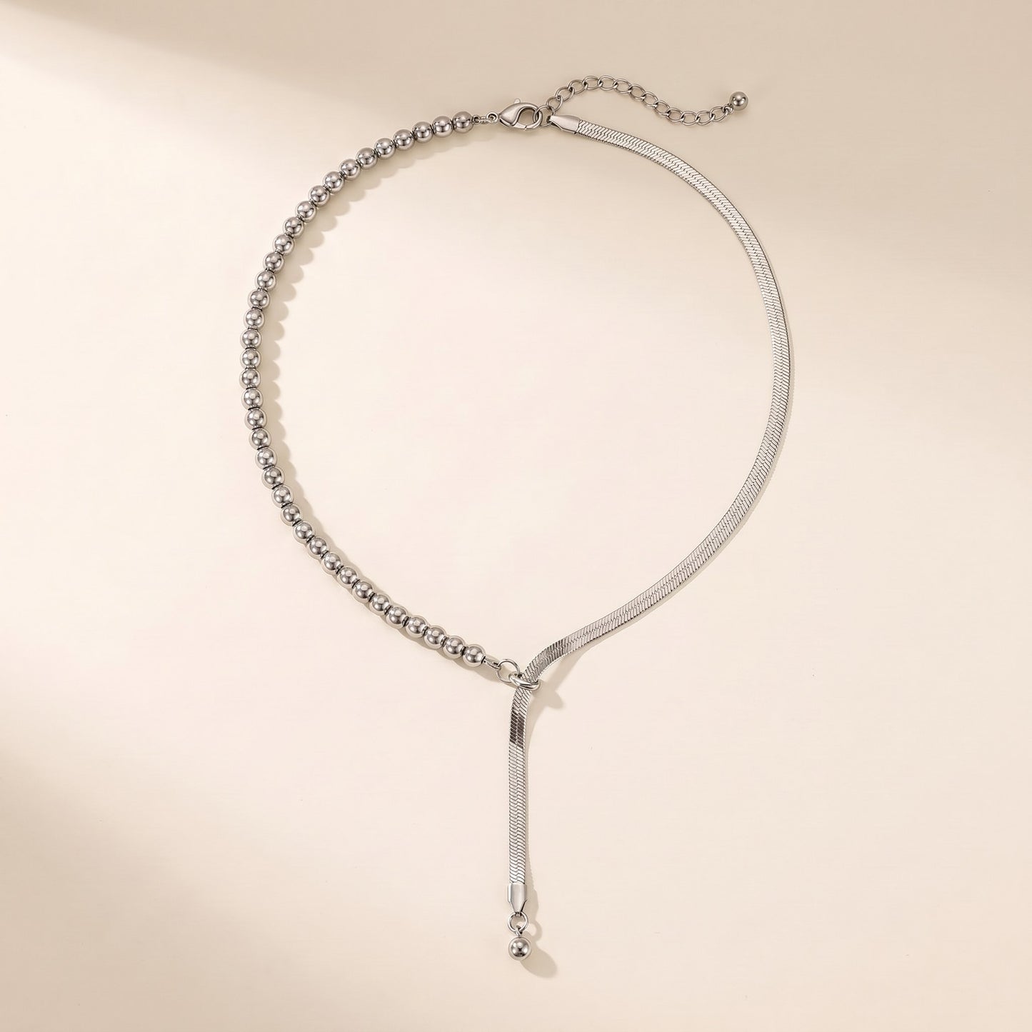 Collana Neo aperta: meta sfere e meta catena herringbone piatta, acciaio argento