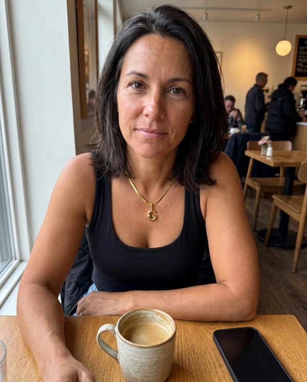 Collana Alma con iniziale G indossata al bar, foto di una cliente