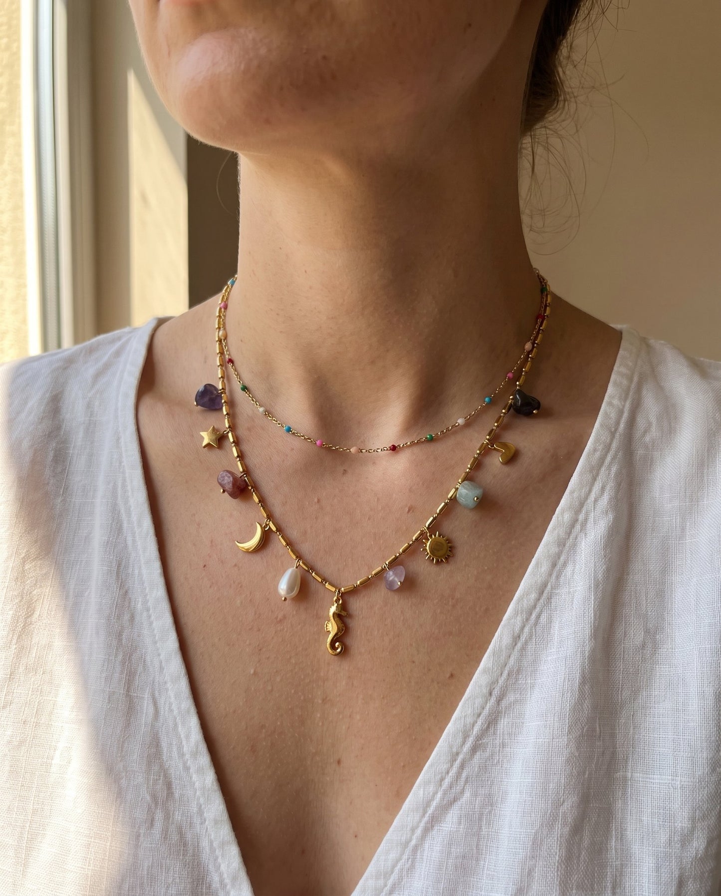 Collana Riva indossata: filo corto con perline smaltate e filo lungo con i charm